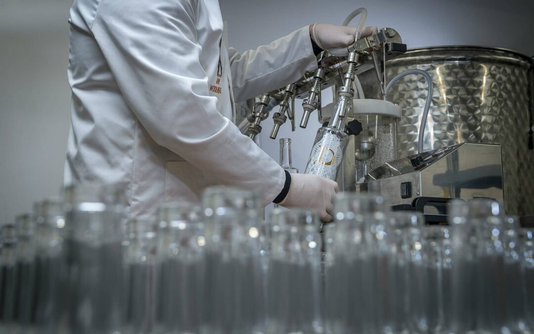 a person filling bottles with a filling machine